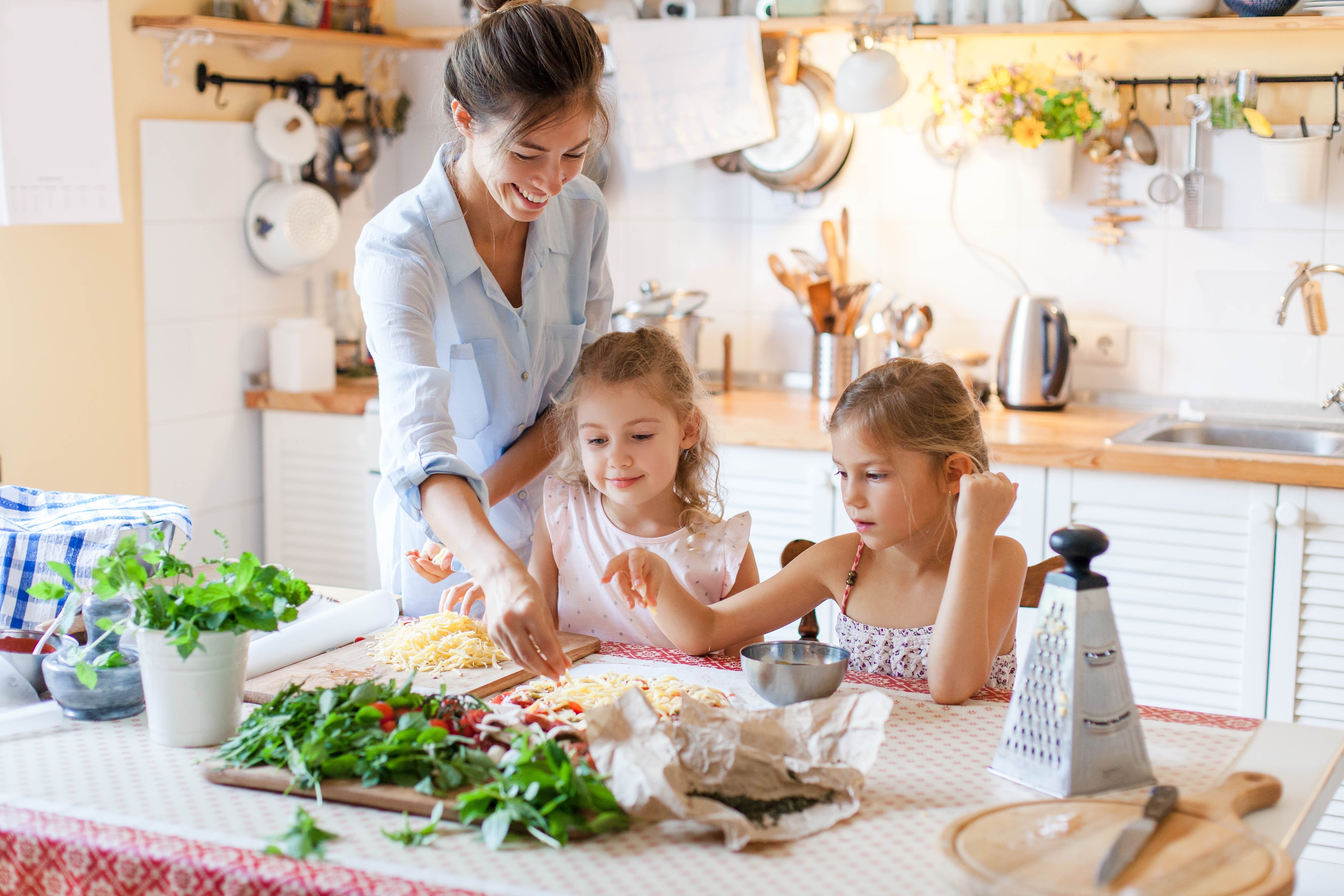 Happy family preparing food with cheese and vegetables to be cooked in the Zoomgoods AF34 dual air fryer