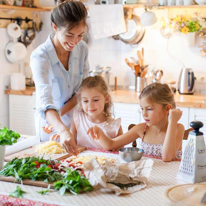 Happy family preparing food with cheese and vegetables to be cooked in the Zoomgoods AF34 dual air fryer