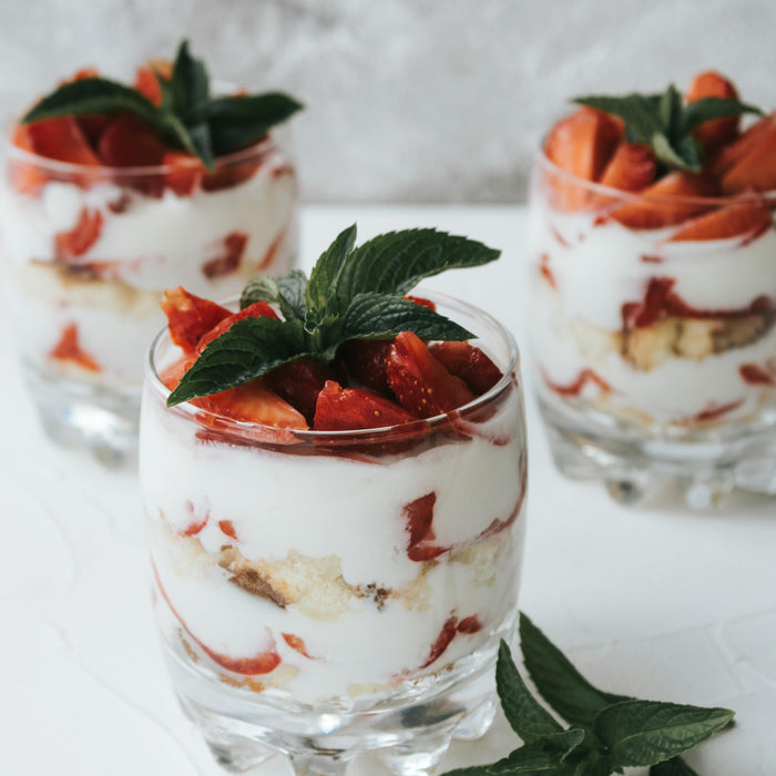 glass pots of fresh homemade yoghurts with strawberries made using the Zoomgoods electric yoghurt maker