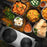 Zoomgoods HP2 SS portable double hot plate surrounded by aesthetically pleasing dishes like butter chicken, naan, rice, biryani
