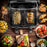 Zoomgoods Twin Drawers AFD2 BK view of a dual-basket digital air fryer surrounded by various cooked dishes like steak, salmon, stuffed peppers, and croissants
